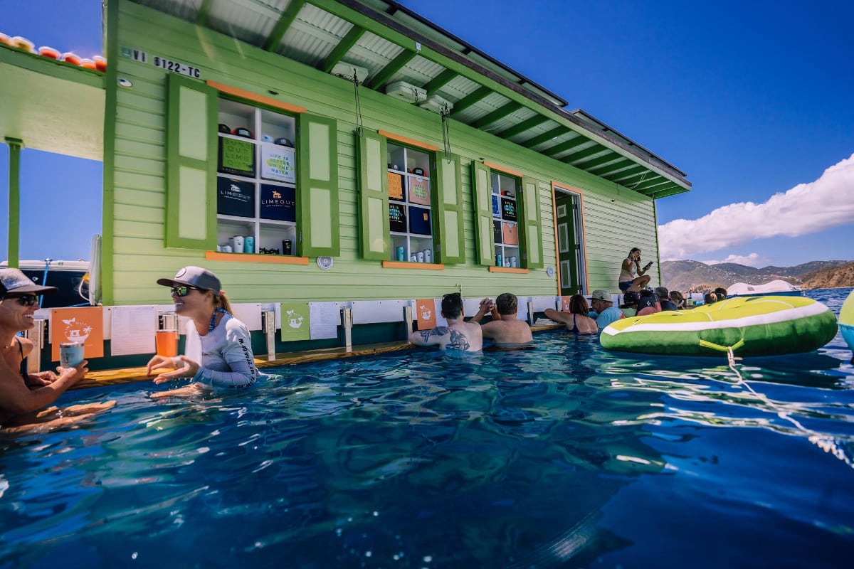 People socializing in water at floating bar
